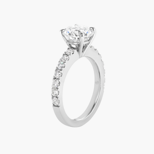 Diamond ring with a central gemstone and smaller diamonds on the band against a white background