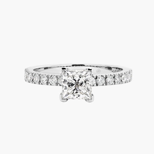 Diamond ring with a central square-cut gemstone and smaller round stones on a white background