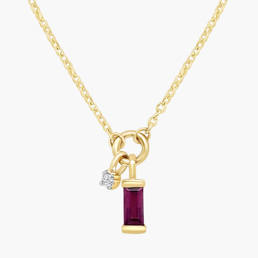 Gold necklace with a red gemstone pendant on a white background