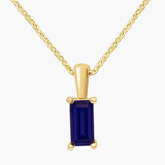 Gold pendant with a blue gemstone on a white background
