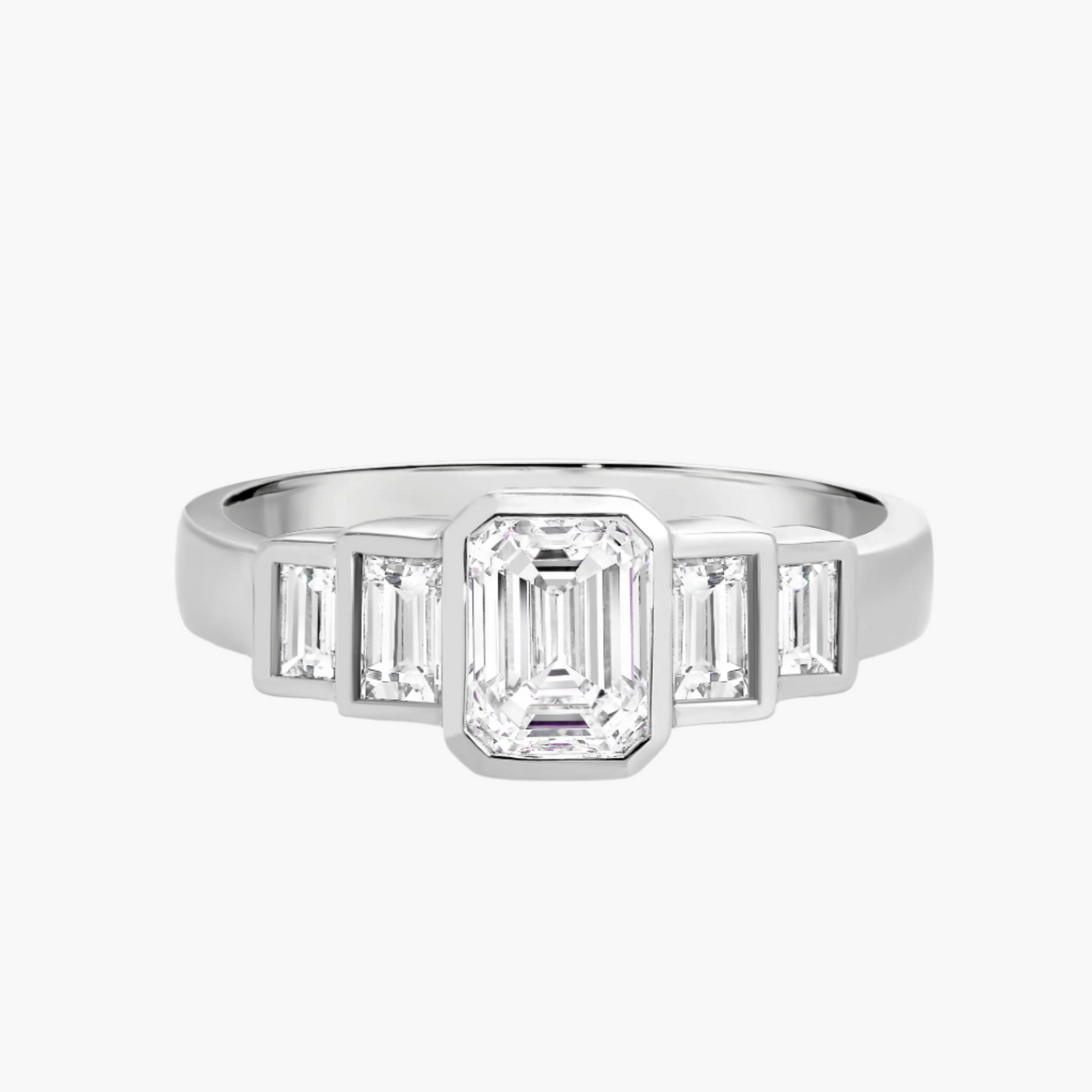 Diamond ring with emerald-cut center stone and baguette side stones on a white background