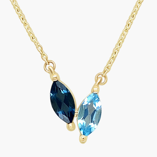 Gold necklace with blue gemstones on a white background