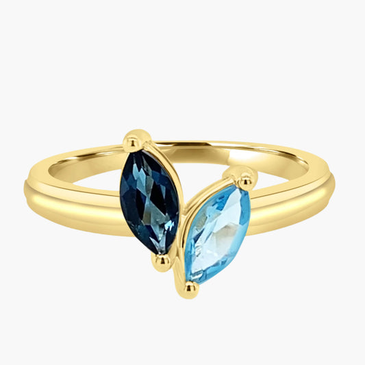 Gold ring with two pear-shaped gemstones on a white background