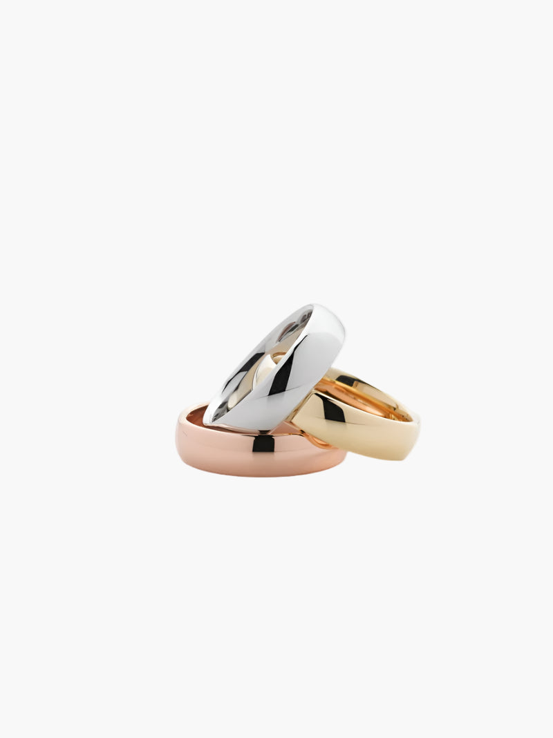 Three gold rings of different colors on a white background