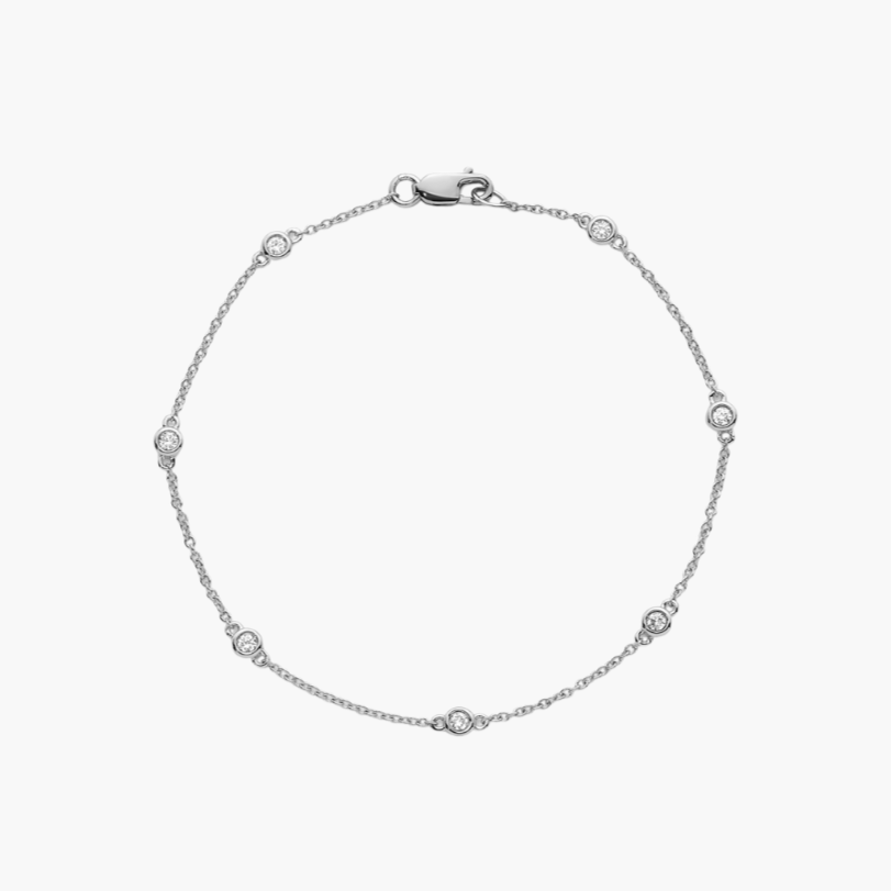Silver bracelet with small diamonds on a light gray background
