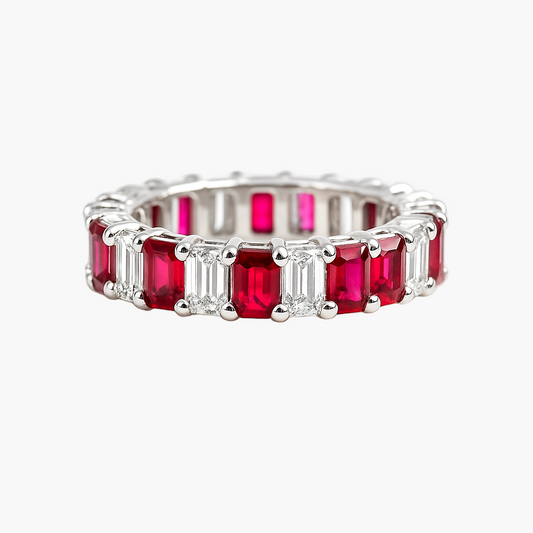 Silver ring with emerald-cut rubies on a white background