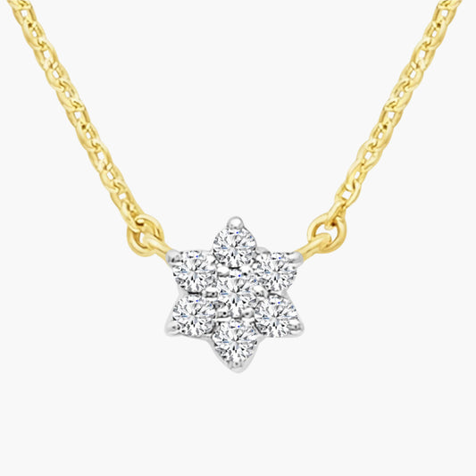 Star-shaped diamond pendant on a gold chain against a white background