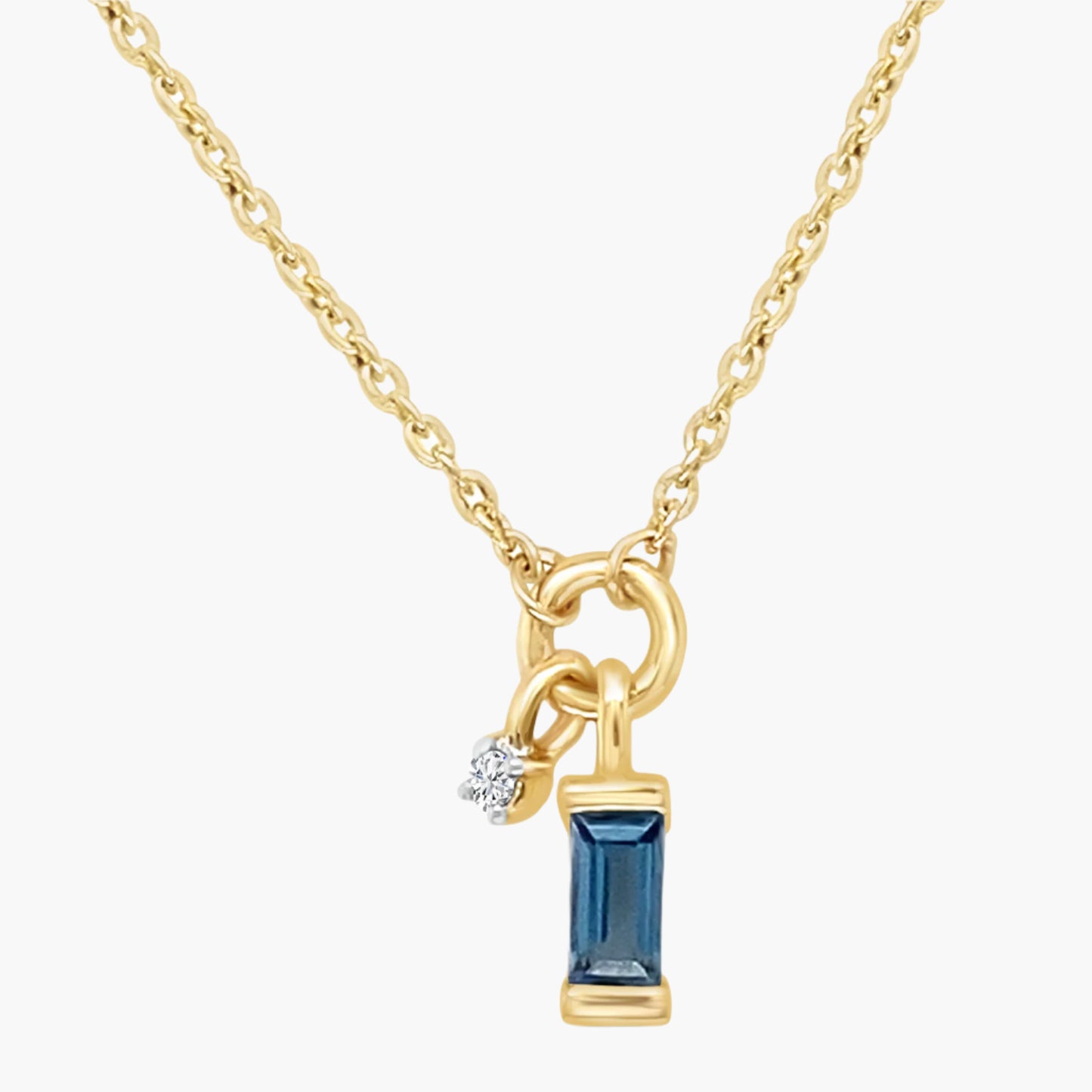 Gold necklace with a blue gemstone pendant on a white background