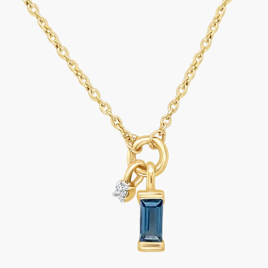 Gold necklace with a blue gemstone pendant on a white background