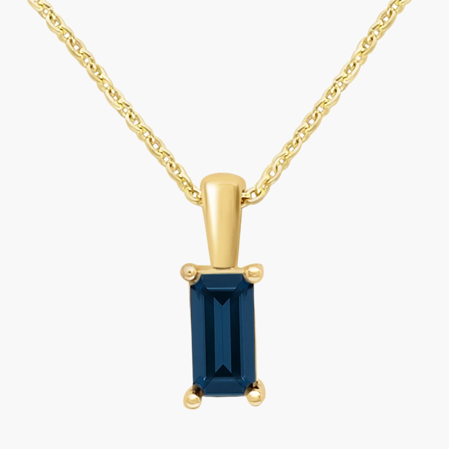 Gold pendant with a blue gemstone on a white background