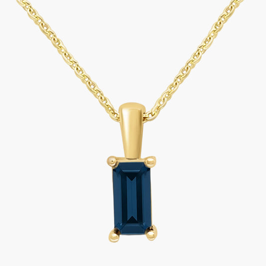 Gold pendant with a blue gemstone on a white background