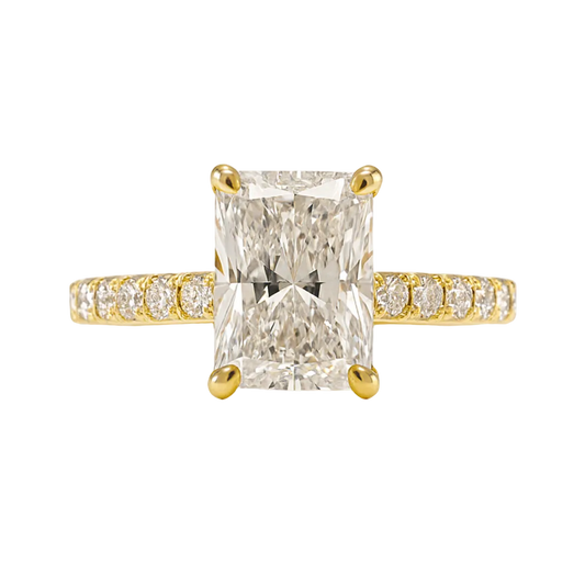 Radiant cut diamond engagement ring in 18ct yellow gold with pavé shoulders and hidden halo