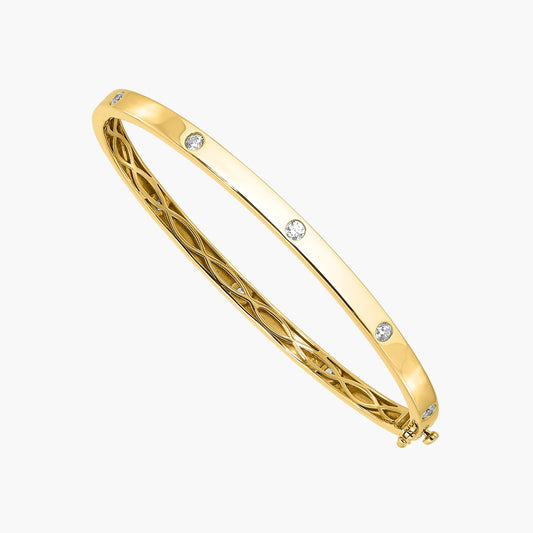 Gold bangle with diamond accents on a white background