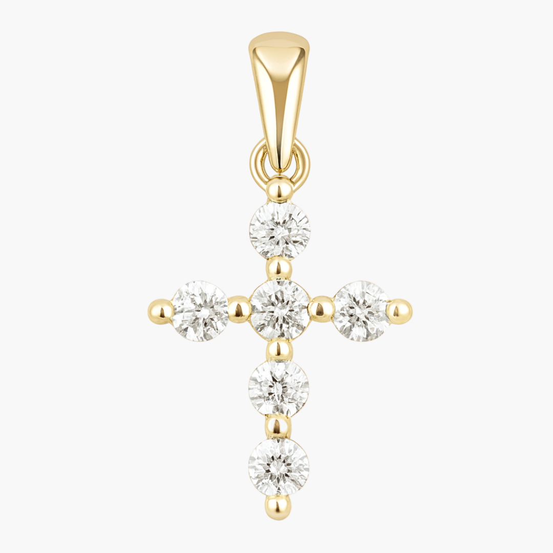 Gold cross pendant with clear gemstones on a white background