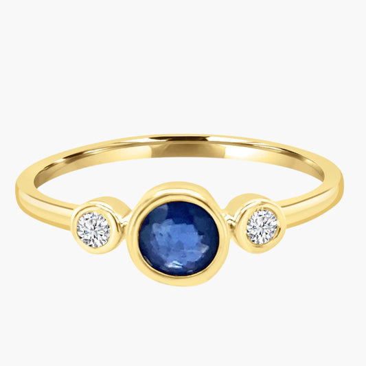 Gold ring with a blue gemstone and two diamonds on a white background